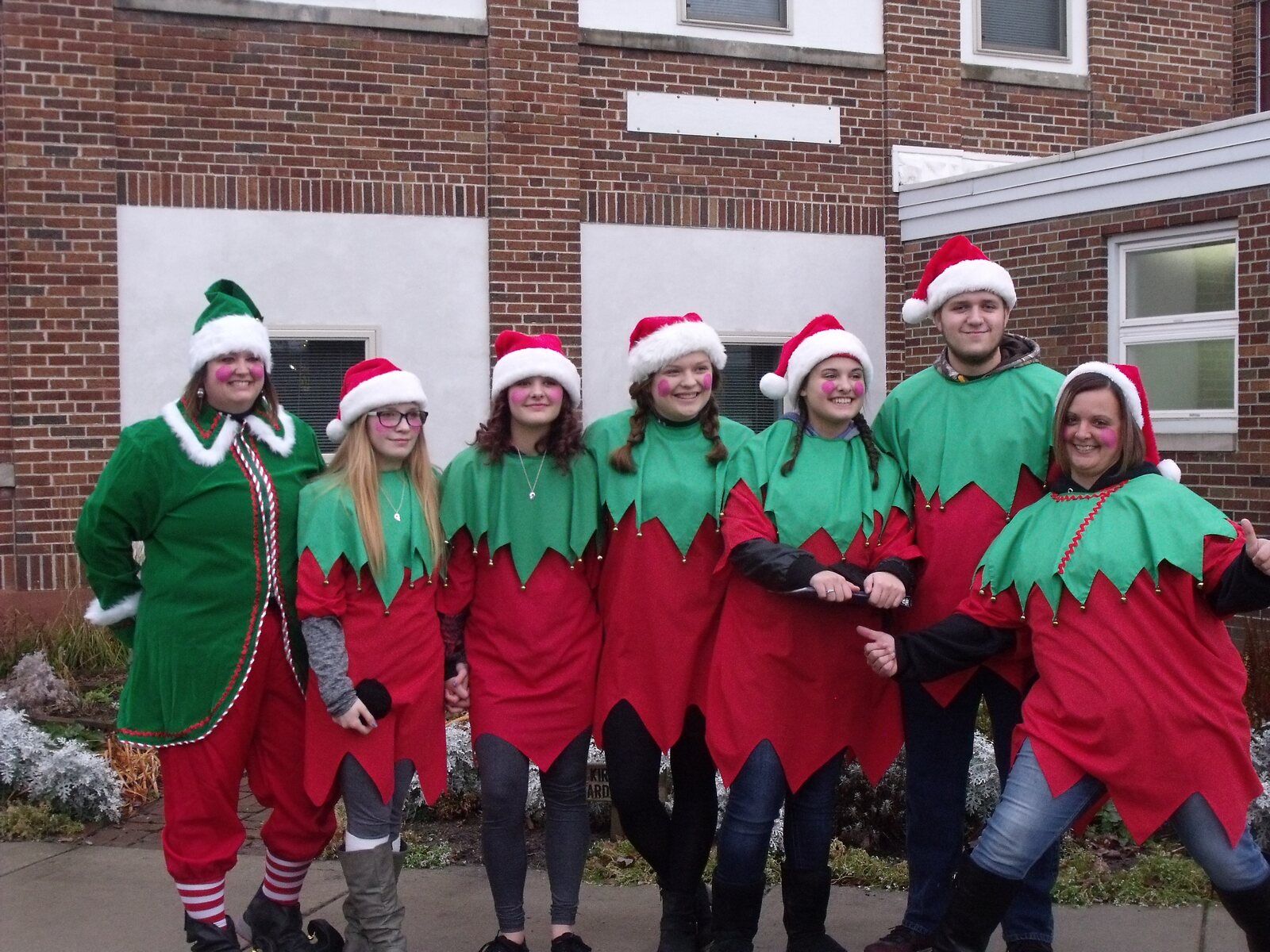 Seven Christmas in the Village volunteers dressed as elves in red and green
